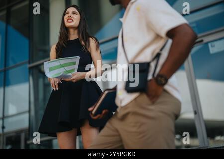 Multicultural businesspeople discussing new projects and marketing strategy outside office building Stock Photo