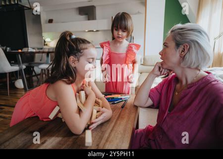 Mother spending quality time with daughters at home playing games Stock Photo