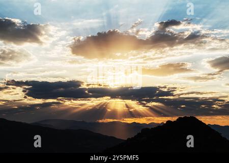 Dawn sunbeams breaking through clouds above the San Gabriel mountains near Los Angeles California. Stock Photo