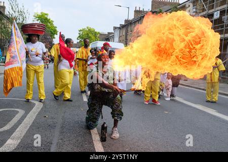 A firebreather from the Gahu Dramatic Arts group wows the crowd during the Hackney Carnival Parade 2024. Stock Photo