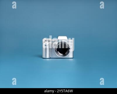 Shiny silver mini vintage camera toy isolated on blue background, minimalist. Photography object tools, investigator, detective, stylish photographer Stock Photo