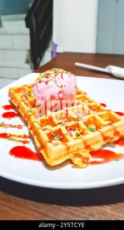 waffle with strawberry ice cream and strawberry sauce on top. Stock Photo
