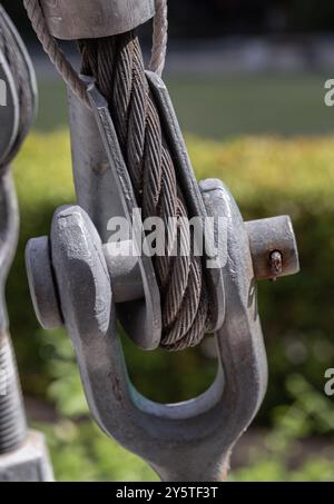 Steel wire rope slings with Thimble and safety anchor shackle turnbuckle connection bolt for heavy work. Metal ring and Steel cabling attached to a sh Stock Photo