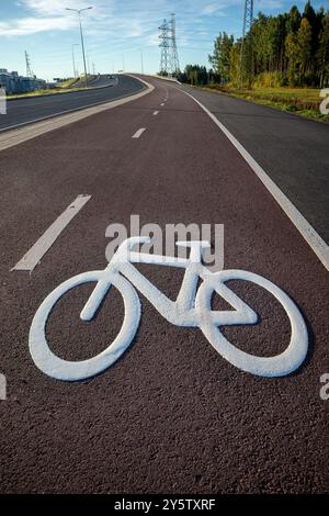 Fresh white bicycle symbol painted on the red tarmac, Oulu Finland Stock Photo