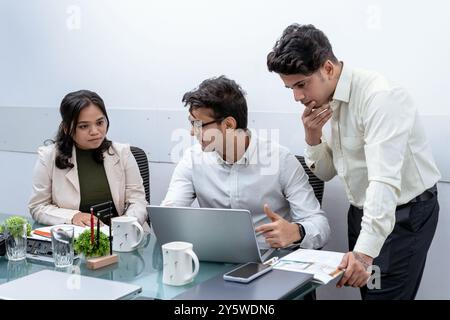 A team of professionals is intensely engaged in a discussion over an important project in a modern office setting is focused and collaborative, highly Stock Photo