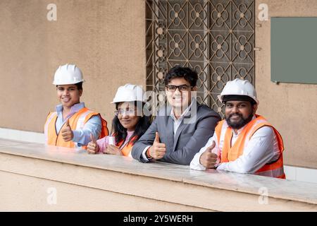 Team of Architects, Engineers, Electricians, and Foremen with Thumbs Up for Integrity, Reliability, Professionalism, Team Collaboration, Project management Stock Photo
