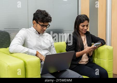 Indian job seekers, interview preparation, and professional development where two serious Indian candidates preparing for an interview in a modern off Stock Photo