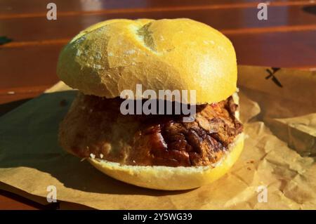 Als Fleischkäse, Leberkäse oder Fleischlaib bezeichnet man eine gebackene Brühwurstsorte. Charakteristisch ist die rechteckige Pastetenform. Die Bezeichnung als Käse leitet sich lediglich von der Form der Laibe ab. In Deutschland muss Leberkäse aus Verbraucherschutzgründen Leber enthalten, es sei denn der Name Fleischkäse oder bayrischer Leberkäse wird verwendet. Dies kommt bei einem Grossteil der Zubereitungen vor. Foto: Leberkäs auf einer Semmel bzw einem Brötchen *** Meatloaf, Leberkäse or Fleischlaib is the name given to a baked type of cooked sausage characterized by its rectangular pâté Stock Photo