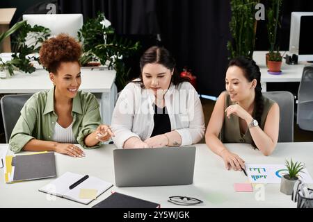 Three professionals engage in productive brainstorming around a laptop in a modern workspace. Stock Photo