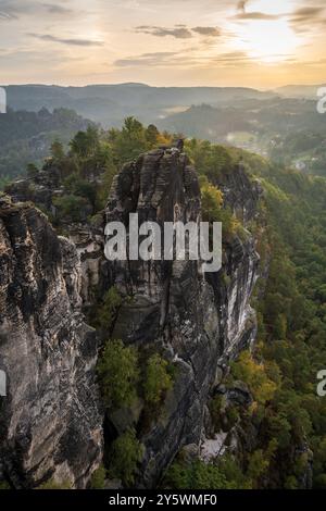 A rock formation beside sunlit river water with rough texture, natural ...