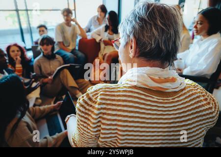 A teacher engaging with students in an informal class setting, encouraging open dialogue and active participation. Stock Photo