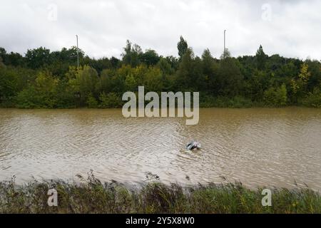 The open boot of a car is visible above the water where the vehicle is submerged in flood water on a421 in Marston Moretaine, Bedfordshire. Parts of Britain have been struck by flash floods after some areas saw more than a month's worth of rain in 24 hours. Heavy rainfall has seen parts of Northamptonshire, Bedfordshire and London submerged causing widespread travel disruption and damage to properties. Picture date: Monday September 23, 2024. Stock Photo