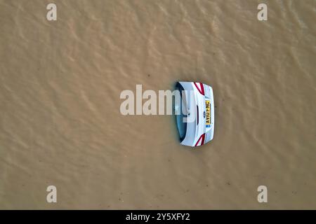 The open boot of a car is visible above the water where the vehicle is submerged in flood water on a421 in Marston Moretaine, Bedfordshire. Parts of Britain have been struck by flash floods after some areas saw more than a month's worth of rain in 24 hours. Heavy rainfall has seen parts of Northamptonshire, Bedfordshire and London submerged causing widespread travel disruption and damage to properties. Picture date: Monday September 23, 2024. Stock Photo