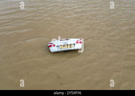 The open boot of a car is visible above the water where the vehicle is submerged in flood water on a421 in Marston Moretaine, Bedfordshire. Parts of Britain have been struck by flash floods after some areas saw more than a month's worth of rain in 24 hours. Heavy rainfall has seen parts of Northamptonshire, Bedfordshire and London submerged causing widespread travel disruption and damage to properties. Picture date: Monday September 23, 2024. Stock Photo