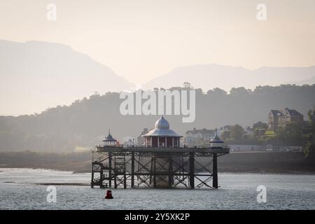 Bangor Pier seen on a misty morning from the Isle of Anglesey Yns Mon across the Menai Strait in North Wales with the Snowdonia mountains behind. Stock Photo