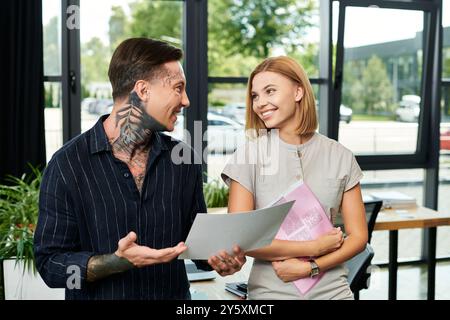 Two coworkers engage in a lively discussion while exchanging ideas at work. Stock Photo