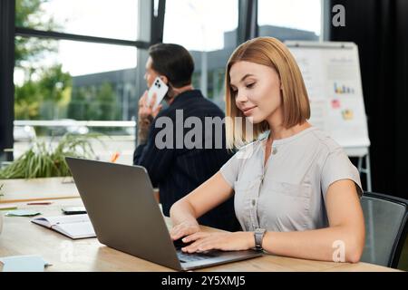 Two young professionals collaborate in a stylish office environment, focusing on their work. Stock Photo