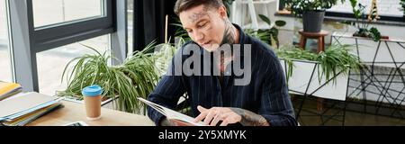 A young coworker reviews documents while surrounded by greenery in a vibrant workspace. Stock Photo