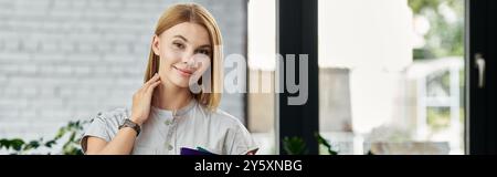 Cheerful woman with blonde hair working in her office. Stock Photo