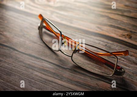 Folded old wooden glasses lying on wooden table Stock Photo