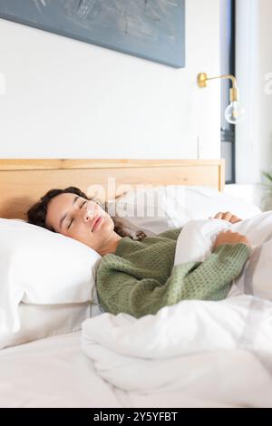 Relaxing in bed, woman sleeping peacefully under white blanket in bedroom, copy space Stock Photo