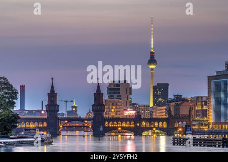 The Spree river in Berlin with the Oberbaum bridge and the TV Tower at twilight Stock Photo