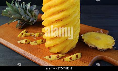 Peeled and nicely cut fresh ripe pineapple on a wooden cutting board Stock Photo