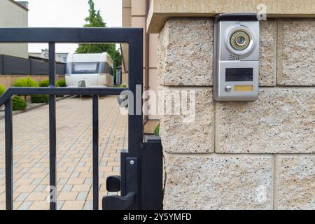 Gated driveway with video intercom system and caravan parked Stock Photo