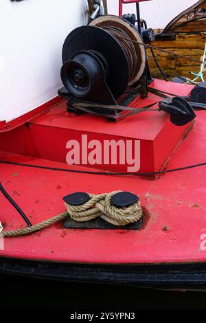 Close up of a boats winch and rope on a red deck Stock Photo