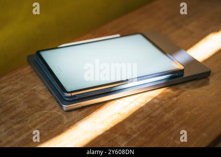 Poland, Poznan, July 15 2024, iPad Pro 4 gen MacBook Pro M1 on wooden table Stock Photo