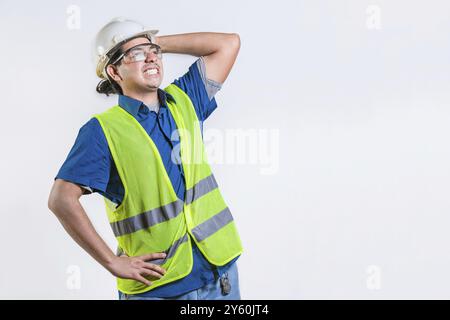 Engineer in problems holding head isolated. Troubled young engineer holding head isolated. Worried builder engineer holding head Stock Photo