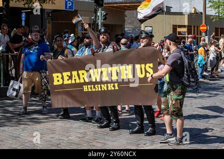 Bearded men with Bear with Us banner at Helsinki Pride 2024 parade in Helsinki, Finland Stock Photo