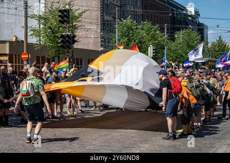 Bear with Us Helsinki. Men waving a giant International Bear Brotherhood Flag at Helsinki Pride 2024 parade on Mannerheimintie in Helsinki, Finland. Stock Photo