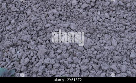 fine gray crushed stone as a textured background full frame, building material screenings and gravel scattered on the surface, waste material Stock Photo
