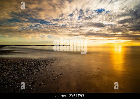 long pause shot at sunset on a Mediterranean beach, water movement, golden hour and landscape inspiring tranquility and fullness Stock Photo