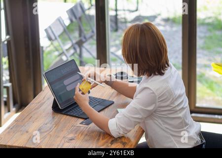 A businesswoman is using a credit card to pay for online shopping during breaks to get the items she wants from online stores without having to travel Stock Photo