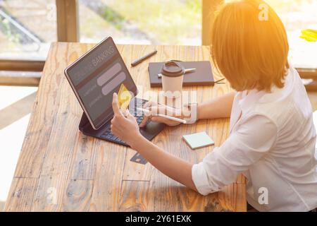 A businesswoman is using a credit card to pay for online shopping during breaks to get the items she wants from online stores without having to travel Stock Photo
