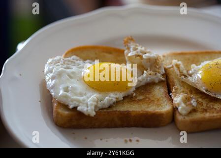 Freshly prepared sunny side up eggs on buttered toast Stock Photo