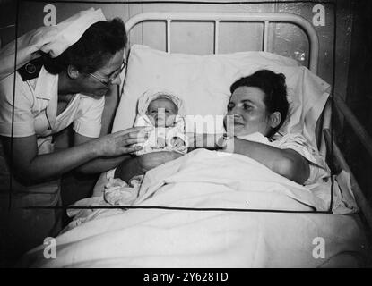 Easily the youngest passenger aboard the 'Aquitainia', sailing from Southampton for Halifax, Nova Scotia, today was Olga Anna Hrycaj, who set out from Amsterdam yesterday when only 2 1/2-hours-old. With her mother she was flown to London airport so that they could catch the ship, taking them to join their baby's father, a Pole who has emigrated to Canada. Today mother and baby were both comfortable in the ships hospital as they set out across the Atlantic. Picture shows: Mrs Hrycaj and baby Olga Anna, just a day old, pictured in the the hospital of the Cunard White Star liner 'Aquitainia' befo Stock Photo