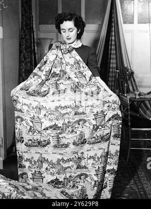 Agents from 185 overseas fashion houses will see the new collection of dress and furnishing fabrics created by Halle's (overseas) Ltd. The new show, now being seen in London includes designs and colouring processing something of the exotic Eastern atmosphere, while prices range from a few shillings per yard up to 14 and 15 shillings per yard for Macclesfield silks. Picture shows:  Covered with quaint scenes of Chinese life, this pure silk crepe de chine dress fabric is called "Emperor of China" and is shown at Halle's Fabric exhibition.  8 December 1947 Stock Photo
