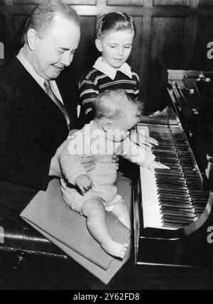 Josef Hoffman lets his baby son Peter play the piano at his Philadelphia home looking on is Edward Hoffman's seven year old son Peter Stock Photo