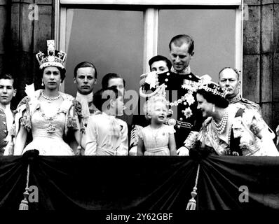 Coronation Day - With a charmingly grandmotherly smile, Queen Elizabeth, The Queen Mother, stoops to ask an enchanted Princess Anne whether she is enjoying the RAF fly-past as members of the Royal family stand on the balcony of Buckingham Palace after the Coronation at Westminster Abbey. Prince Charles looks to his father, The Duke of Edinburgh, who smiles down on  his daughter, Princess Anne. The Queen, wearing the Imperial state crown, gazes at the crowds milling around the gates of the Palace. Background, left to right, The Duke of Gloucester, uncle of the Queen. 2nd June 1953 Stock Photo