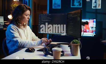 Teleworking system administrator futureproofing company network from downtimes and unexpected failures. Remote IT employee typing on keyboard, increasing data security, camera B Stock Photo