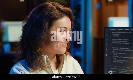 Joyous woman doing software quality assurance celebrating after reading source code and finding no errors. Cheerful engineer excited after inspecting coding on desktop PC, seeing no issues, camera A Stock Photo