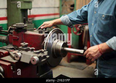 Mechanic turns on the grinding lathe Stock Photo