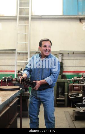 Smiling mechanic loads brake discs for delivery Stock Photo
