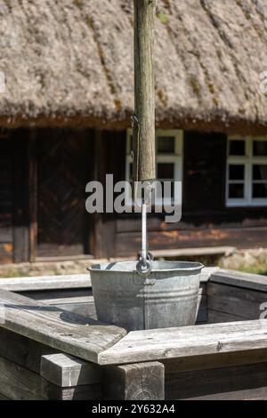 Old wooden well with a bucket on a pulley Stock Photo