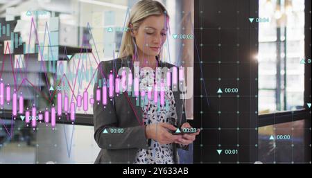 Analyzing financial data charts over businesswoman using smartphone in office Stock Photo