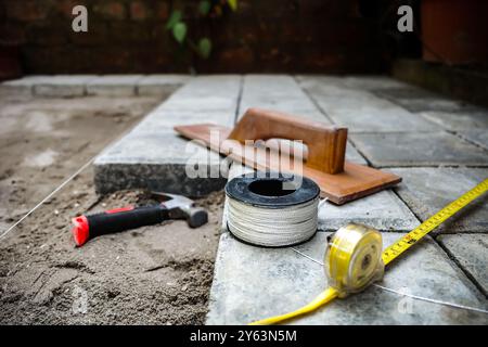 Closeup view of tools used for paving block floor construction work for backyard patio Stock Photo