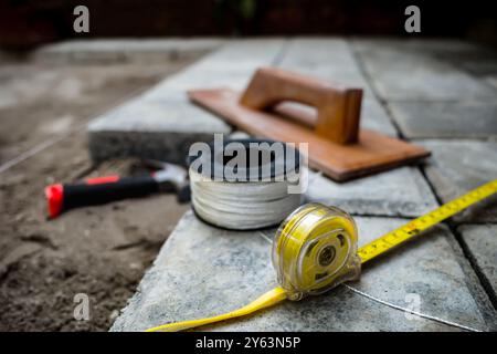 Closeup view of tools, utensils and materials used for paving block floor construction work Stock Photo